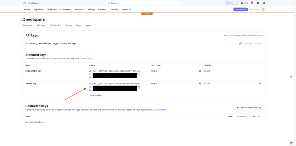  The Stripe dashboard with an arrow showing where to look for API keys. The keys are blackend out to hide sensitive information.